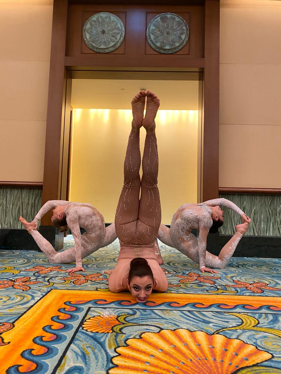 Acrobatic trio performing a balanced pose